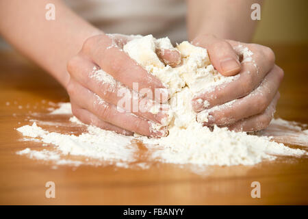 Close up cuisine maison, femme mains pétrir la pâte sur la table en bois Banque D'Images