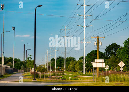 Vue vers le bas de la route et de poteaux de signalisation sur une journée claire montrant de grandes quantités de câblage électrique Banque D'Images