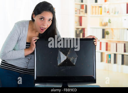 Femelle brune à la casse sur écran d'ordinateur avec l'expression du visage choqué sur son visage. Banque D'Images