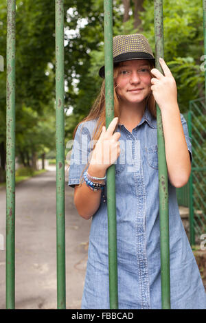 Jeune fille en denim robe et chapeau, se tient dans le parc. Banque D'Images