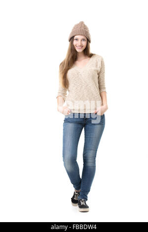 Beautiful happy smiling teenage girl posing timide dans les tenues, en essayant sur nouvelle tenue - tricot beige hat, jersey, Jean et al. Banque D'Images