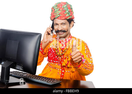 1 Rural indien Gujrati homme ordinateur qui fonctionne et le Téléphone Mobile Multi Tasking Banque D'Images