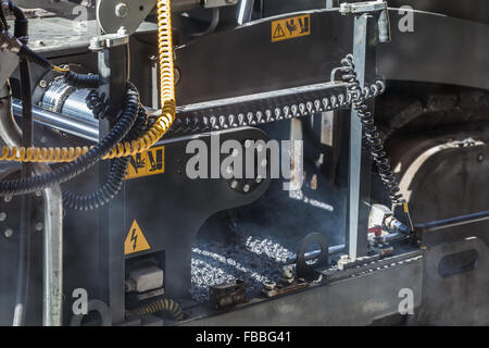 La route en milieu urbain est en cours de construction. Fragment de la machine à paver de travail Banque D'Images