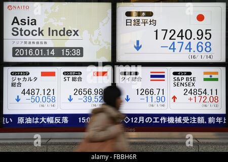 Tokyo, Japon. 14 janvier, 2016. Une femme passe devant un panneau indiquant le prix des actions japonaises le 14 janvier 2016 à Tokyo, Japon. En dépit des signes de reprise le mercredi, le Nikkei 225 Stock Average a terminé la journée en baisse de 2,7  % à 17 240,95. D'autres marchés à travers l'Asie ont également subi le pétrole a chuté en dessous de 30 dollars le baril et les inquiétudes persistent au sujet de la croissance chinoise. Credit : Ito Shingo/AFLO/Alamy Live News Banque D'Images