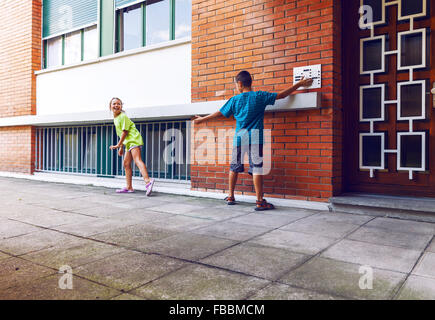 Les enfants sonner la cloche et s'enfuir Banque D'Images