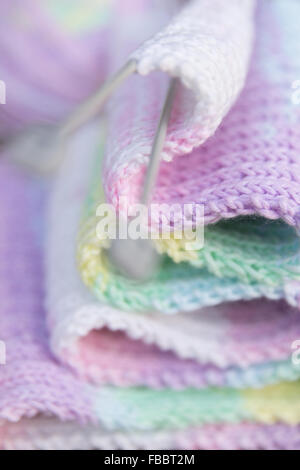 Des aiguilles à tricoter écharpe texturée en tricot multicolore pastel rose gros plan détail d'artisanat Banque D'Images