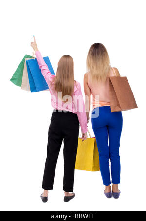 Vue arrière de deux femmes avec des sacs à dos. avis de personne. Vue arrière personnes collection. Plus isolé sur fond blanc. Deux filles avec les sacs en papier à quelque chose dans le ciel. Banque D'Images