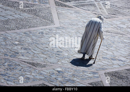 Homme marocain traditionnel dans une Djellabah promenades dans la médina de Chefchaouen, Maroc. Banque D'Images