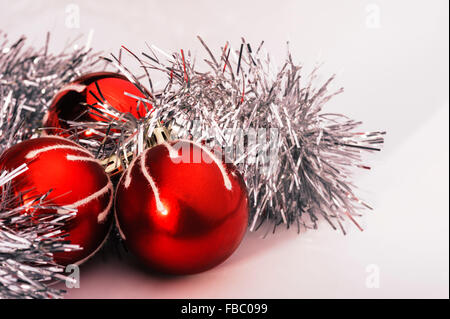 Trois boules rouges et de guirlandes d'argent. Banque D'Images