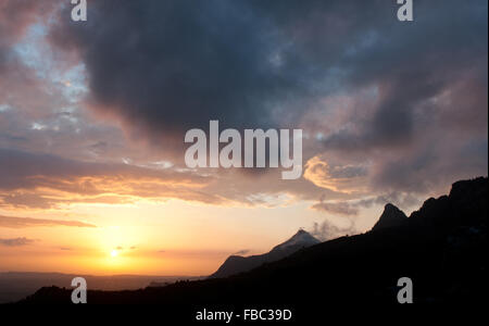 Gamme de montagne et ciel orageux dramatiques avec nuages noirs avant le coucher du soleil. Banque D'Images