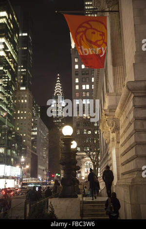 À l'est le long de la rue 42e la NY Public Library avec le Chrysler building illuminé en arrière-plan. Banque D'Images