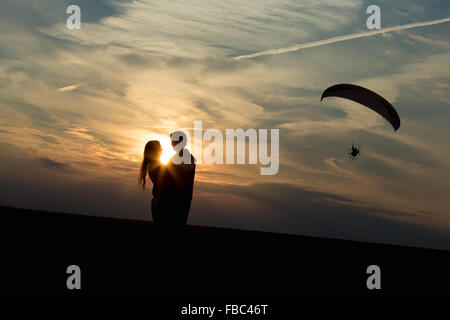 Couple d'amants contre vaste horizon sur le coucher du soleil ou le lever du soleil, étreignant l'un l'autre, debout sur la distance d'un baiser, inhabituelle Banque D'Images