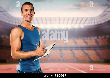 Image composite de Young coach sportif, writing on clipboard Banque D'Images