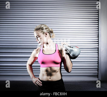 Image composite de la femme de soulever de lourdes kettlebell Banque D'Images