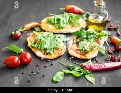 Mini pizzas d'épinards frais, le basilic et les épices Banque D'Images