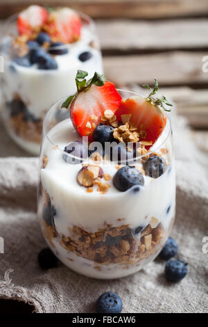 Petit-déjeuner sain avec yaourts, céréales et fruits frais Banque D'Images