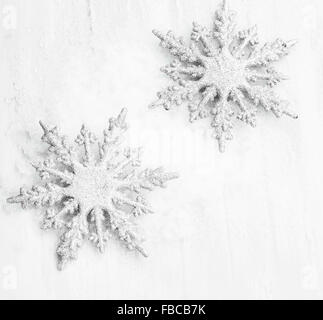 Deux d'argent scintillait Flocons de Noël ornements dans la neige Banque D'Images