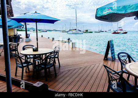 Vue sur le port et les bateaux de beachside café avec tables et chaises de Christiansted, Îles Vierges des États-Unis. Banque D'Images