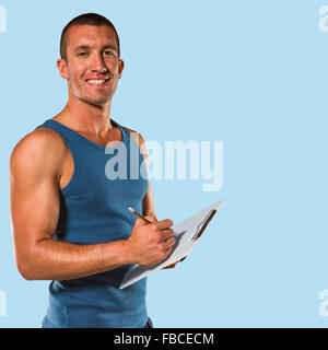 Image composite de Young coach sportif, writing on clipboard Banque D'Images