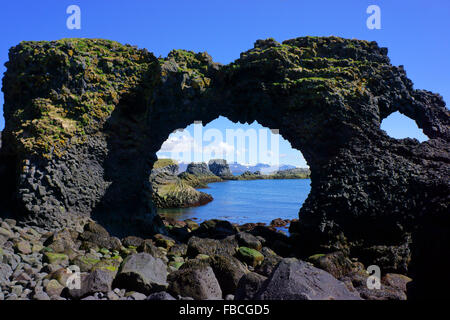 Littoral et falaises de basalte à Arnarstapi nature reserve vu à travers le trou de la falaise. La péninsule de Snaefellsness, Islande Banque D'Images