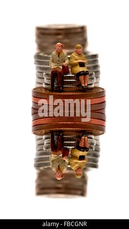 Miniature 2 personnes retraités assis sur des piles de pièces de monnaie britanniques traduit numériquement Banque D'Images