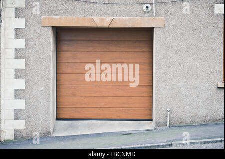 Une porte de garage en bois fermée dans un mur de pierre d'une maison Banque D'Images