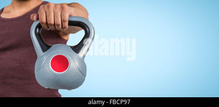 Image composite de la mi section d'un homme tenant une musculaire kettlebell Banque D'Images