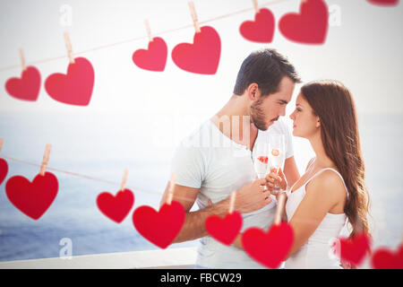 Image composite de cute couple toasting with champagne Banque D'Images