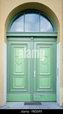 Une double porte en bois vert dans une arche en pierre Banque D'Images