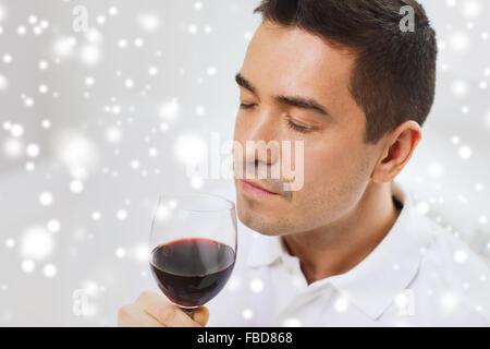 Homme heureux de boire le verre de vin rouge à la maison Banque D'Images