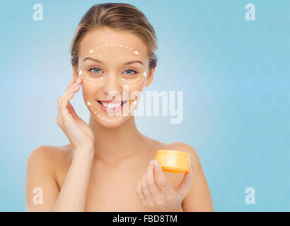 Happy young woman l'application de la crème Banque D'Images
