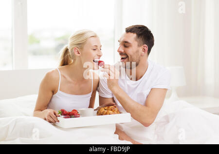 Heureux couple having breakfast in bed at home Banque D'Images