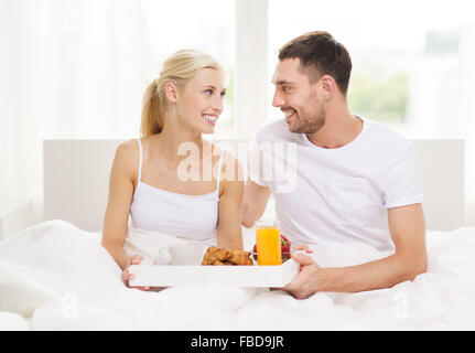 Heureux couple having breakfast in bed at home Banque D'Images