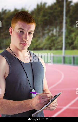 Image composite de l'ajustement personal trainer writing on clipboard Banque D'Images