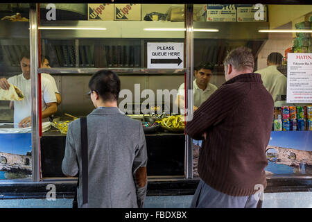 Deux hommes attendent leur nourriture à emporter, supérette, Bristol, UK Banque D'Images