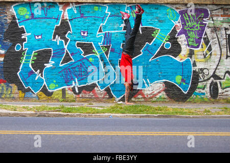 Un spectacle d'HipHop danseur en face d'un mur de graffiti. Banque D'Images