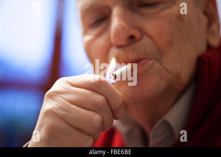 Homme âgé allumer une cigarette Banque D'Images