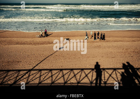 Les hommes, les femmes et les chiens se promener le long de la Mer Cantabrique, plage de sable fin, Bilbao, Espagne, Banque D'Images