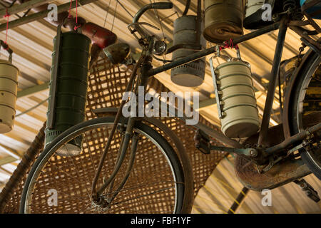 Meubles anciens et divers contenants tiffin vélo suspendu à un plafond, dans l'arrière-salle d'un restaurant à Georgetown Penang. Banque D'Images