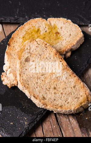 Des tranches de pain au cours de la préparation de l'entrée de l'italien typique : 'bruschetta' Banque D'Images