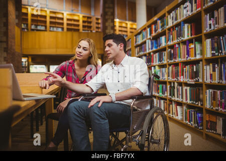 En étudiant avec un camarade de travail en fauteuil roulant Banque D'Images