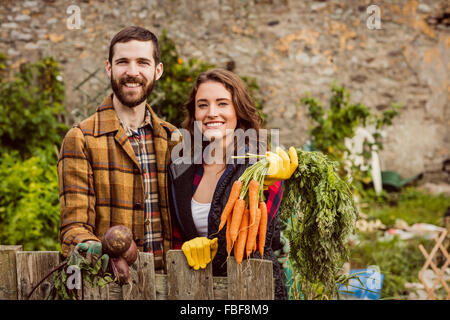 Young couple holding vegetables Banque D'Images