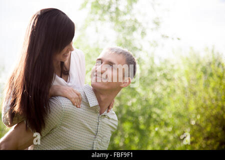 Couple in love sur une date, jeune homme donnant sa belle petite amie piggyback ride, happy smiling, avoir du plaisir ensemble, spa copie Banque D'Images