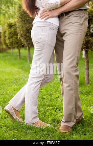 Couple in love, séduisant jeune homme et femme sur la date romantique dans la région de park, étreignant l'un l'autre, Close up de jambes Banque D'Images