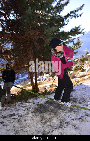 Woman in pink jacket slackline dans la neige dans le Queyras, France Banque D'Images