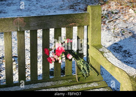 Sur le banc de parc commémoratif de fleurs Banque D'Images