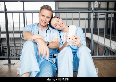 Smiling medical team sitting on floor Banque D'Images