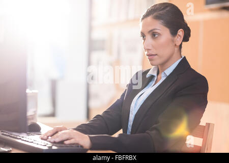De graves businesswoman working at her desk Banque D'Images