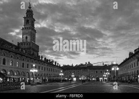 Beaux nuages dans le ciel au-dessus de la ville, tour carrée entourée de vieux lampadaires en Italie durant l'hiver Banque D'Images