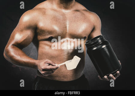 Image composite de l'homme musclé avec des protéines en poudre Banque D'Images